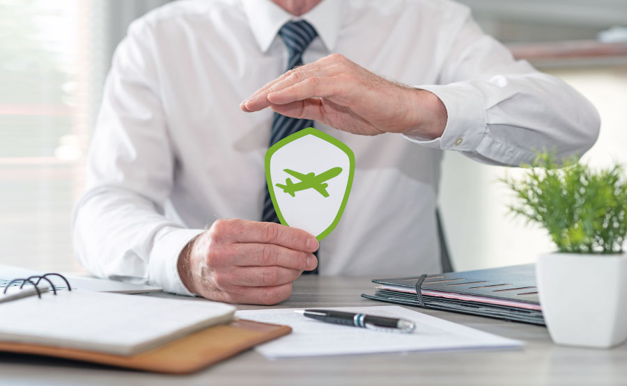 Ein Versicherungsexperte aus Leipzig hält ein grünes Schild mit einem Flugzeugsymbol in den Händen, um Schutz und Absicherung für Reisen zu symbolisieren. Eine rechtzeitig abgeschlossene Reiseversicherung sorgt für finanzielle Sicherheit und unbeschwertes Reisen.