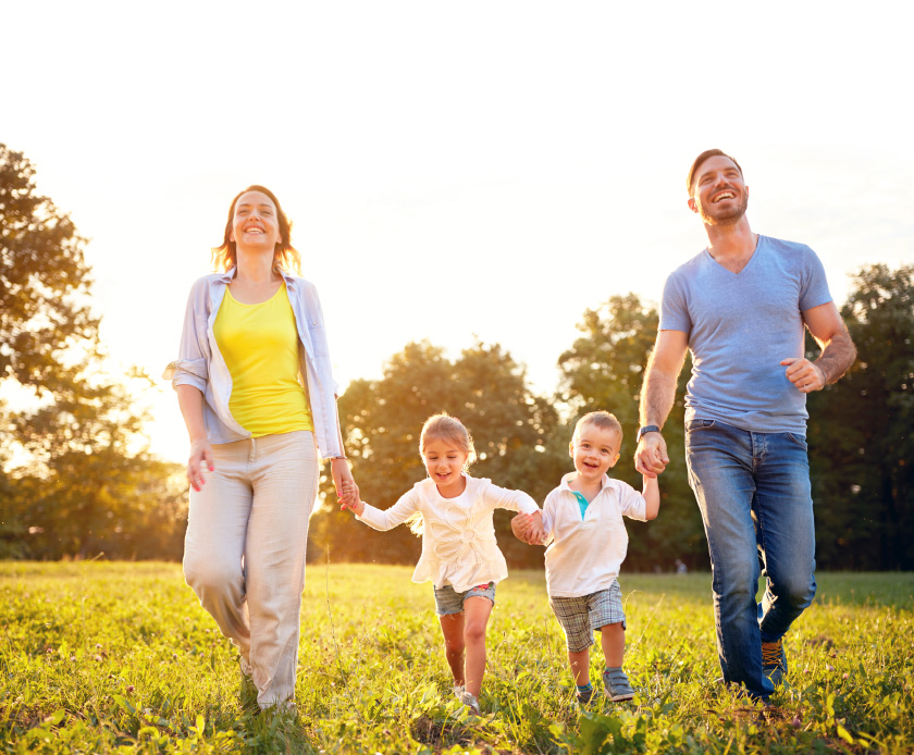 Fröhliche Familie mit zwei kleinen Kindern läuft Hand in Hand über eine sonnige Wiese. Alle lachen und genießen den Moment in der Natur. Das Bild symbolisiert Lebensfreude, Sicherheit und Geborgenheit. Eine passende Versicherungsberatung in Leipzig sorgt dafür, dass Familien wie diese rundum abgesichert sind – von Gesundheit über Haftpflicht bis zur Altersvorsorge.
