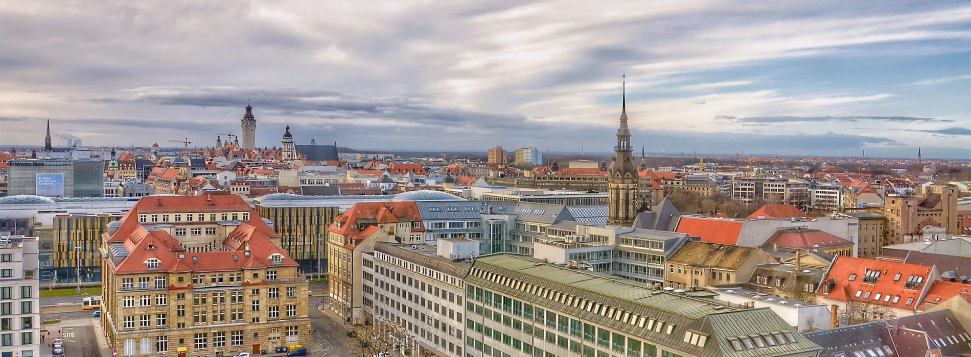 Panoramablick über die Stadt Leipzig mit historischen Gebäuden und moderner Architektur – Symbol für verlässliche Finanz- und Versicherungsberatung vor Ort.