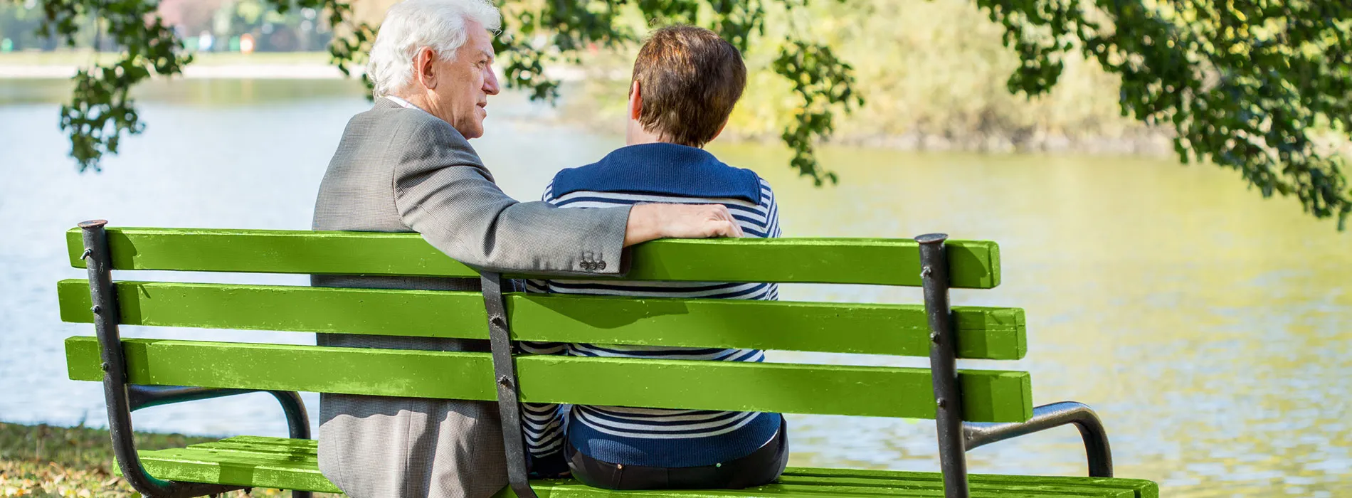  Ein älteres Paar sitzt auf einer grünen Parkbank am See und unterhält sich – Symbolbild für Beiträge rund um Versicherungen, Altersvorsorge und Finanzthemen im News- und Blogbereich aus Leipzig.