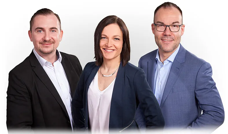 Drei professionelle Finanz- und Versicherungsexperten der Finanzkompass GmbH Leipzig stehen nebeneinander vor einem neutralen weißen Hintergrund. Die Gruppe besteht aus André Brumme, Claudia Liebmann und Marcus Aßmann, alle tragen Business-Outfits in dunklen Farbtönen und lächeln freundlich. Das Bild symbolisiert Kompetenz und Vertrauen in der unabhängigen Finanz- und Versicherungsberatung und vermittelt einen modernen und sympathischen Eindruck.