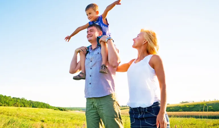 Eine Familie im Freien symbolisiert Sicherheit und Zukunftsplanung durch Lebensversicherung und Altersvorsorge.