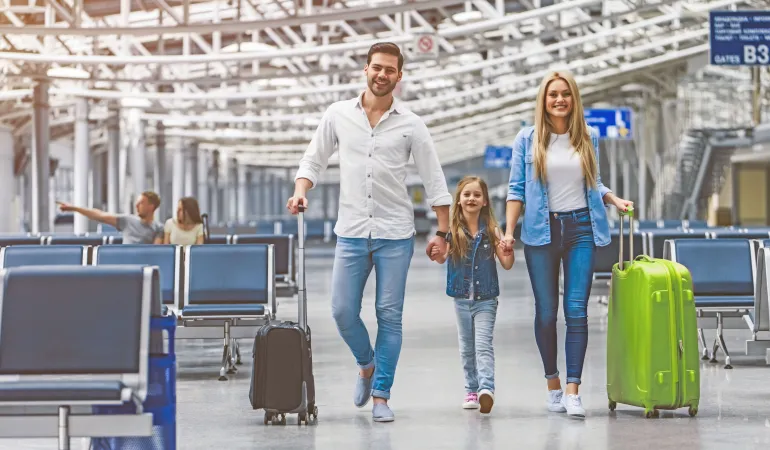Familie auf dem Weg zum Flieger - Reiseversicherung für den Urlaub 2025 rechtzeitig abschließen