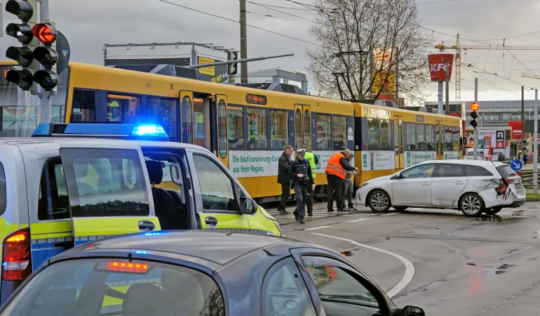Unfall zwischen PKW und Straßenbahn an Kreuzung – Polizei und Einsatzkräfte sichern den Bereich nach einem Arbeitsunfall im Stadtverkehr