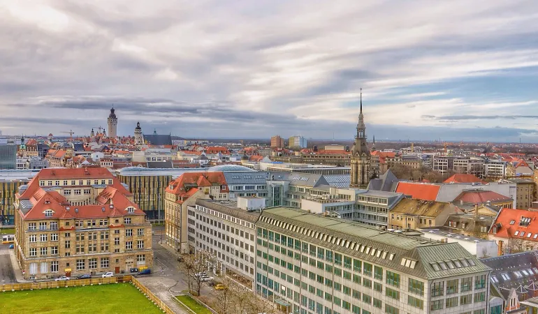 Panoramablick über die Stadt Leipzig mit historischen Gebäuden und moderner Architektur – Symbol für verlässliche Finanz- und Versicherungsberatung vor Ort.