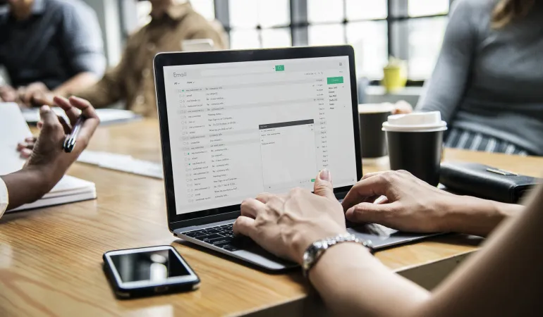 Mitarbeitende am Schreibtisch mit Laptop und E-Mail-Kommunikation – Informationsaustausch zur Direktversicherung in der betrieblichen Altersvorsorge