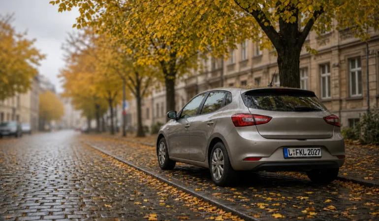 Silbernes Auto an einer herbstlichen Straße mit Altbauten.