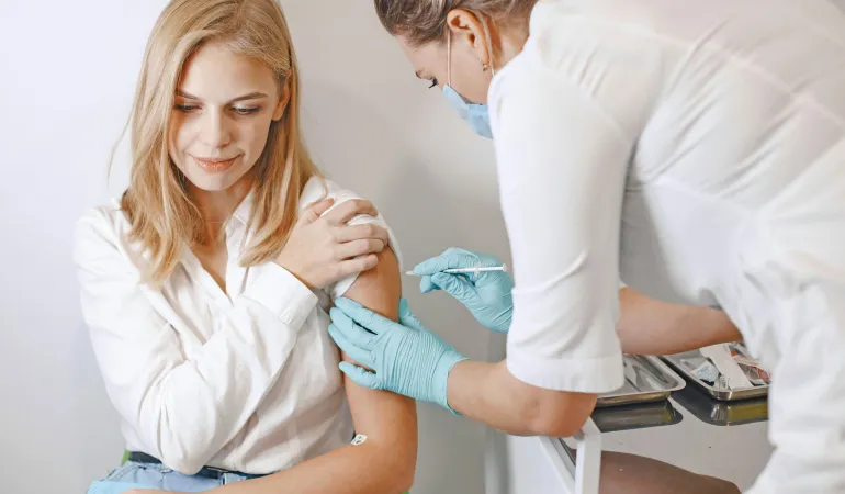 Junge Frau erhält Impfung in einer Arztpraxis – Symbolbild für Gesundheitsleistungen nach Krankenkassenwechsel in Leipzig