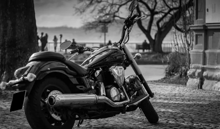  Schwarzes Motorrad auf Kopfsteinpflaster vor stimmungsvoller Kulisse – Symbolbild für eine zuverlässige Motorradversicherung und Haftpflicht in Leipzig.