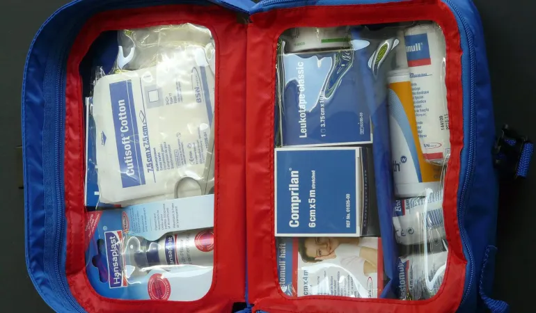 Ein geöffnetes Erste-Hilfe-Set mit Verbandsmaterial, Pflastern und medizinischen Hilfsmitteln – ordentlich sortiert in einer blauen Tasche mit rotem Reißverschluss. Das Bild steht symbolisch für Vorsorge und Schutz im Ernstfall. Eine private Berufsunfähigkeitsversicherung in Leipzig bietet finanzielle Sicherheit, falls die eigene Arbeitskraft durch Krankheit oder Unfall verloren geht.