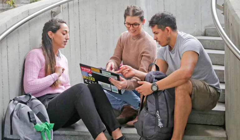 Drei junge Erwachsene sitzen auf einer Treppe und sprechen gemeinsam über Möglichkeiten nach dem Schulabschluss – Thema Schulabgänger ohne Ausbildungsplatz